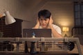 Asian freelancer feeling overwhelmed and stressed working overtime during nightshift Royalty Free Stock Photo