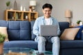 Asian Freelancer Guy Sitting With Laptop Working Online At Home