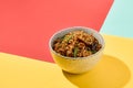 Asian fried buckwheat noodles with chicken on coloured background Fried noodles in ceramic bowl on yellow, red and blue background