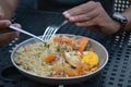 Asian fried rice with vegetables and sunny side egg scooped with spoon and fork with blurred background. Royalty Free Stock Photo