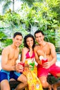 Asian friends drinking cocktails at pool Royalty Free Stock Photo