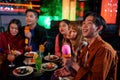 Asian friends singing into microphone at karaoke party at club Royalty Free Stock Photo