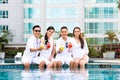 Asian Friends sitting by hotel swimming pool Royalty Free Stock Photo