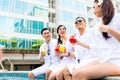 Asian Friends sitting by hotel swimming pool Royalty Free Stock Photo