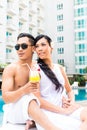 Asian Friends sitting by hotel swimming pool Royalty Free Stock Photo