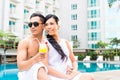 Asian Friends sitting by hotel swimming pool Royalty Free Stock Photo