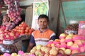 Asian fruit seller sitting at his stall and waiting for customers