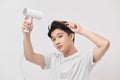 Asian fun young man 20s years old in white shirt hold blow dry hair isolated on white background Royalty Free Stock Photo
