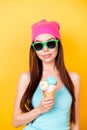 Asian funky hipster is posing for photo, wearing tourist`s outfit, glasses, hat, holds ice cream, so cool, attractive and