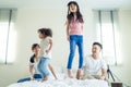 Asian funny family feel happy to spend time together on bed at home. Loving couple enjoy look to young little girl daughters