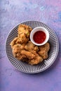 Asian fusion vegan meat-free meal of battered fried broccoli with sweet spicy sauce