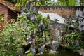 Asian garden decoration. Traditional home garden with fountain, rocks, towers, trees and walls Royalty Free Stock Photo