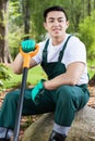 Asian gardener keeping a spade