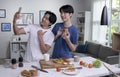 Asian gay couple looking happy while cooking and taking selfie. LGBT men couple preparing meal salad in the kitchen at home Royalty Free Stock Photo