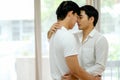 Asian gay couple with white shirt kiss together in bed room with day light