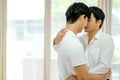 Asian gay couple with white shirt kiss together in bed room with day light