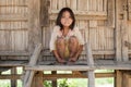 Asian girl Akha before timber house, Laos