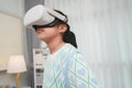 Asian girl amazed by VR headset experience. Immersive edutainment simulation. Royalty Free Stock Photo