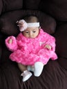 An Asian girl baby wearing a pink shirt lying on the sofa with comfort Royalty Free Stock Photo