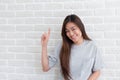 Asian girl beautiful pointing to copy space on the background wall white. Asia women smile on the face happy