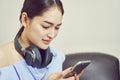 Asian girl in blue casual dress listening to music from black headphones. Royalty Free Stock Photo