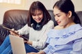 Asian girl in blue casual dress listening to music from black headphones and use laptop. Royalty Free Stock Photo