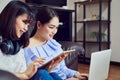 Asian girl in blue casual dress listening to music from black headphones and use laptop. In a comfortable and good mood. Royalty Free Stock Photo