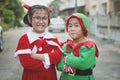 Asian girl and boy wearing santa claus suit playing with happiness outdoor Royalty Free Stock Photo