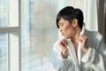 Asian girl, brunette with a short haircut in a white coat is standing near the stained-glass windows, in the morning. against the Royalty Free Stock Photo