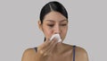 Asian girl cleaning her lips with wet wipes posing on gray beckground concept of make-up