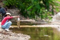 Asian girl collecting garbage and plastic on the river to dumped into the trash.