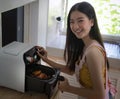 Asian girl cooking a fried chicken by Air Fryer machine Royalty Free Stock Photo