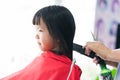 Asian girl cut hair at beauty salon. The hairdresser`s hand gently brushes the hair with skill.