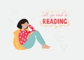 An asian girl with a dark hair in a bright clothing sitting with her back on her yellow pillow and reading a book Royalty Free Stock Photo