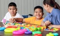 An Asian girl with a disability is practicing the use of hand and finger muscles. By playing with toys