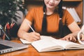 Asian girl doing homework and studying at home. woman using laptop at desk write notes watching webinar, study online, look at Royalty Free Stock Photo
