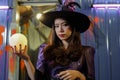 Asian girl dressed as a witch holding a magic crystal ball in hand and casting a spell Royalty Free Stock Photo