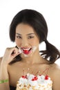Asian Girl eating cherry off Cake