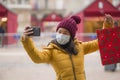 Asian girl enjoying Christmas shopping during covid19 - young happy and beautiful Chinese woman holding red shopping bag taking Royalty Free Stock Photo