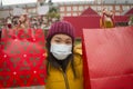 Asian girl enjoying Christmas shopping during covid19 - young happy and beautiful Chinese woman with mask holding red shopping bag Royalty Free Stock Photo