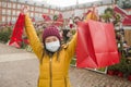 Asian girl enjoying Christmas shopping during covid19 - young happy and beautiful Chinese woman with mask holding red shopping bag Royalty Free Stock Photo