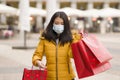 Asian girl enjoying Christmas shopping during covid19 - young happy and beautiful Chinese woman with mask holding red shopping bag Royalty Free Stock Photo