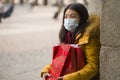 Asian girl enjoying Christmas shopping during covid19 - young happy and beautiful Korean woman with mask holding red shopping bag Royalty Free Stock Photo
