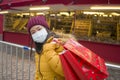 Asian girl enjoying Christmas shopping during covid19 - young happy and beautiful Korean woman with mask holding red shopping bag Royalty Free Stock Photo