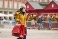 Asian girl enjoying Christmas shopping during covid19 - young happy and beautiful Korean woman with mask holding red shopping bag Royalty Free Stock Photo