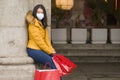 Asian girl enjoying Christmas shopping during covid19 - young happy and beautiful Korean woman with mask holding red shopping bag Royalty Free Stock Photo