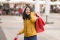 Asian girl enjoying Christmas shopping - young happy and beautiful Japanese woman holding red shopping bag buying presents at Royalty Free Stock Photo