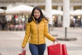 Asian girl enjoying Christmas shopping - young happy and beautiful Korean woman holding red shopping bag buying presents at street Royalty Free Stock Photo