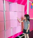 Asian girl enjoys flipping pink partition boards.