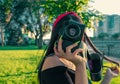 Asian Girl with film camera in the park in sunset time. Brunette girl with photocamera in the vintage colored image Royalty Free Stock Photo